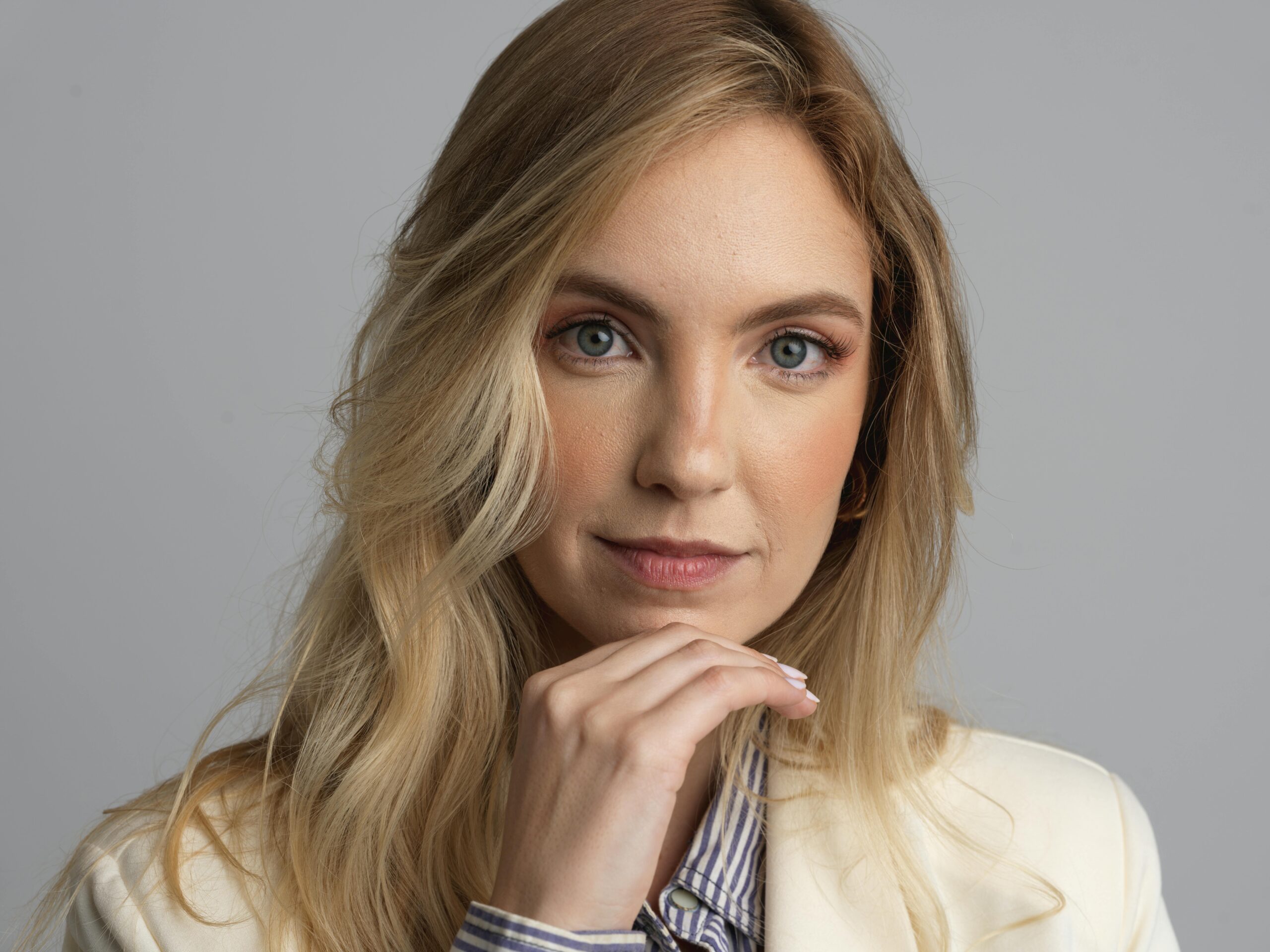 Close-up portrait of a blonde woman wearing a blazer, conveying professionalism.